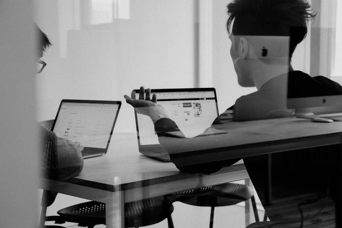 Zwei Personen besprechen Zahlen an zwei Laptops